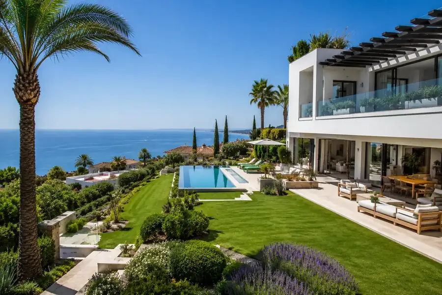 Jardín de villa con olivos y piscina infinita frente al Mediterráneo