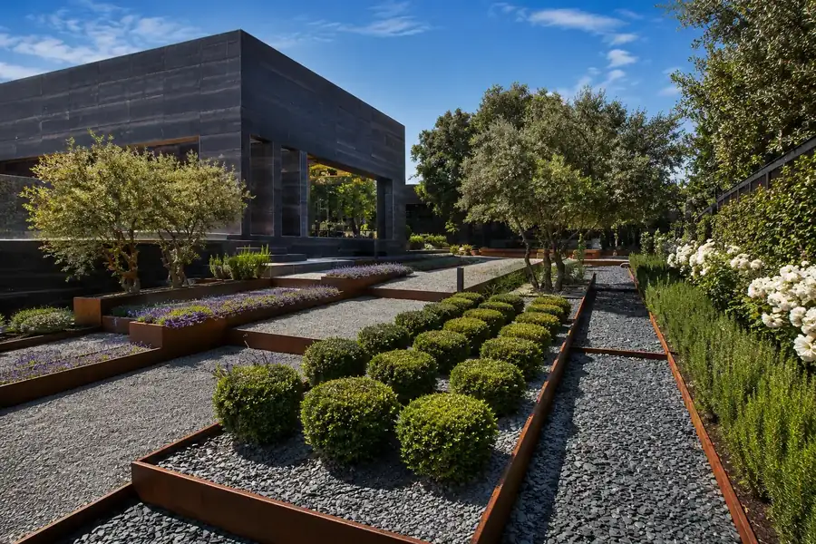 Jardín aterrazado con cipreses y muros de piedra en una finca mediterránea